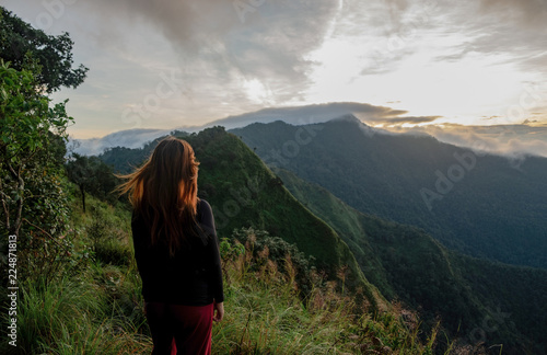 Cute girl hiking adventure on the high mountain with beautiful views of mist. at Doi Phu Kha in Nan. © Wuttichai