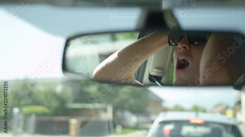 Wallpaper Mural SLOW MOTION, CLOSE UP, DOF: Reflection of a frustrated young man yelling at the car in front of him as he drives through the morning rush hour traffic. Handsome Caucasian male experiencing road rage. Torontodigital.ca
