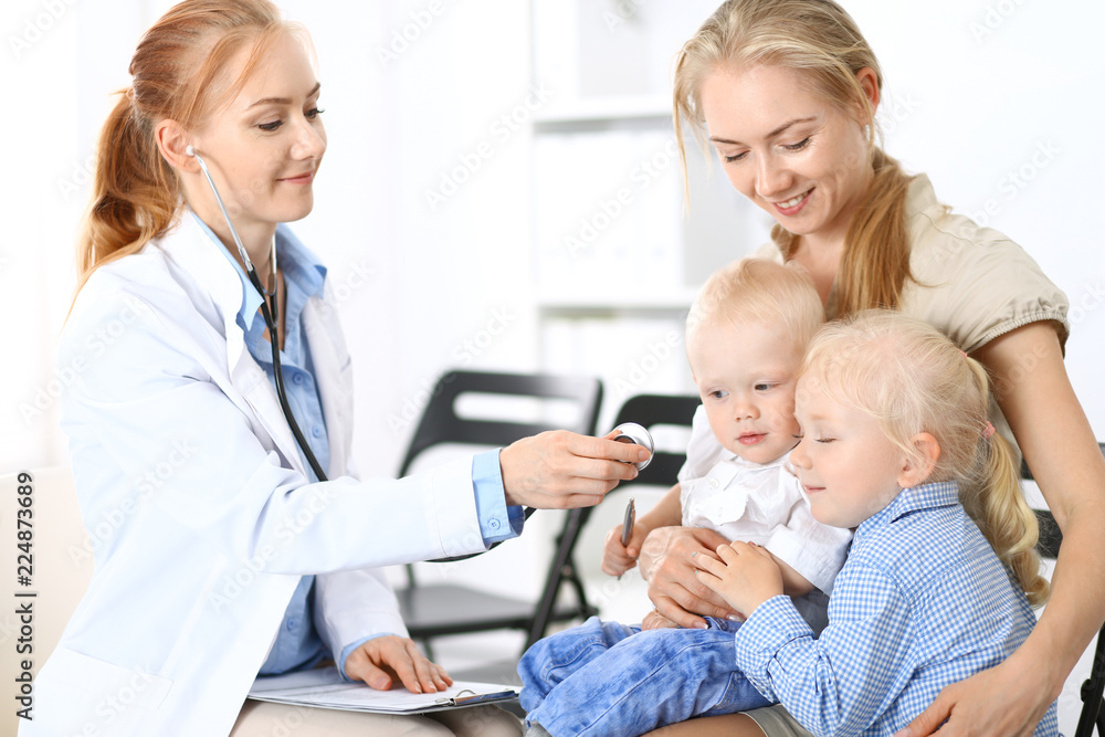 Doctor examining a little boy with stethoscope. Mother holds her son on her lap. Motherless and medicine concept Doctor examining a little boy with stethoscope. Mother holds her son on her lap. Motherless and medicine concept