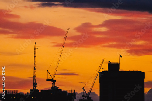 Cranes and buildings on sunset