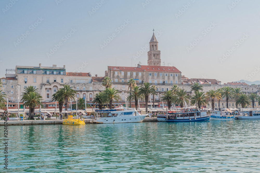 Split, Croatia. Europe. Sea banks with mooring tourist excursion boats. in background Saint Domnius bell tower.