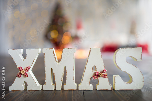Wooden letters Xmas on the blurred christmas background