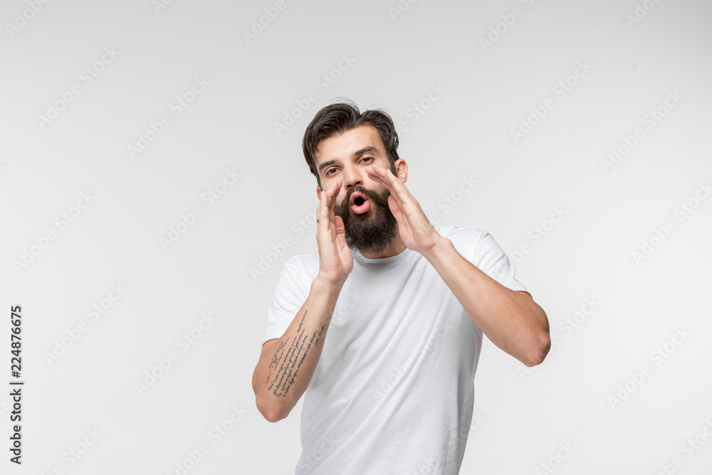 Do not miss. Young casual man shouting. Shout. Crying emotional man screaming on white studio background. male half-length portrait. Human emotions, facial expression concept. Do not miss. Young casual man shouting. Shout. Crying emotional man screaming on white studio background. male half-length portrait. Human emotions, facial expression concept.