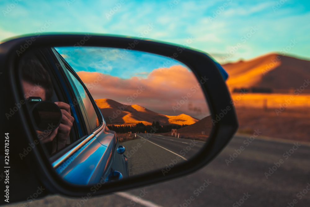 Reflection in side mirror of golden hills