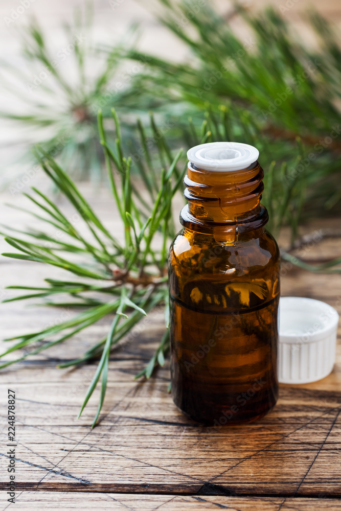 Cedar and spruce essential oil in small glass bottles on wooden background. Selective focus. Cedar and spruce essential oil in small glass bottles on wooden background. Selective focus.