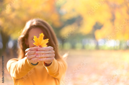 Valokuva girl holds a yellow leaf