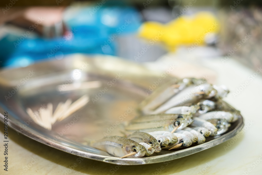 Small anchovies on toothpicks put on silver tray Small anchovies on toothpicks put on silver tray