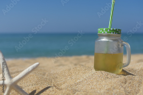Cold refreshment on sandy beach. Summer holidays background, concept of vacations