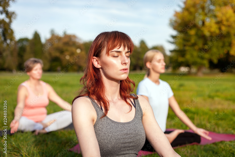 Yoga in the park, young woman doing exercises with group of mixed age people Yoga in the park, young woman doing exercises with group of mixed age people