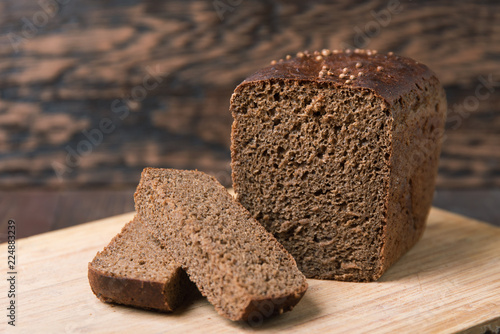 Schilderij op canvas Black rye bread with coriander on a wooden background