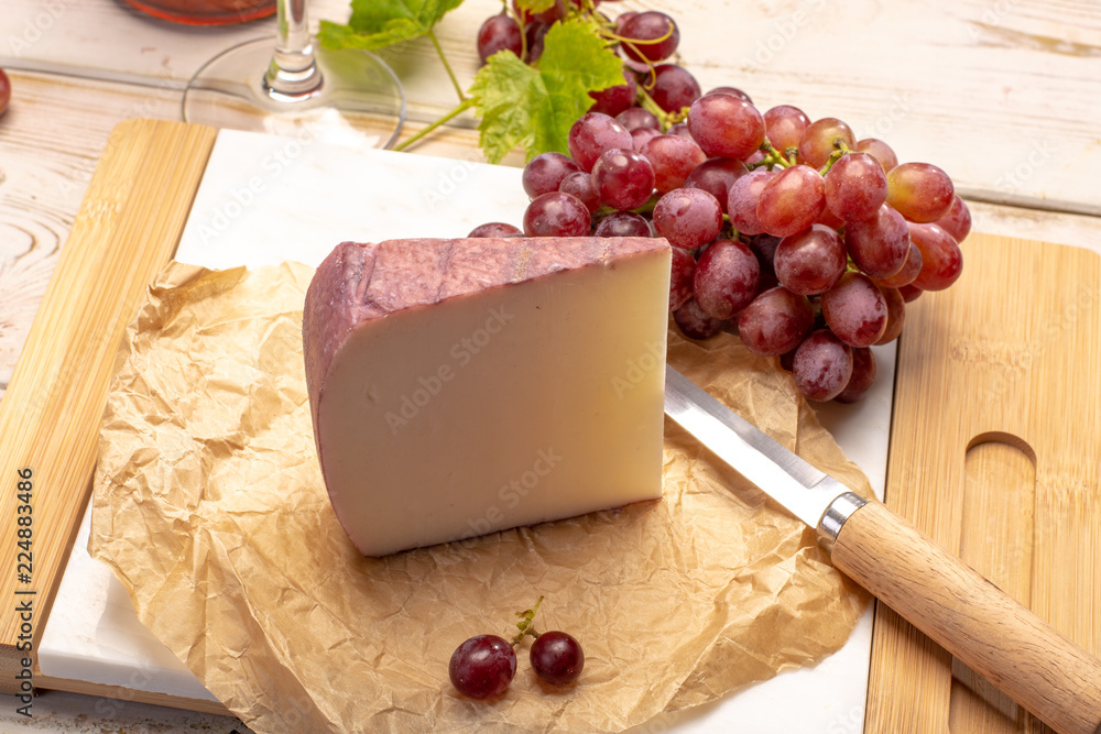 Traditional Spanish cheese, Murcian wine cheese from goat milk with rind washed in red wine, served with fresh ripe grapes