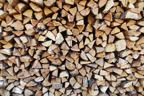 Chopped wood laid in a woodpile to dry for the winter. Wood texture.