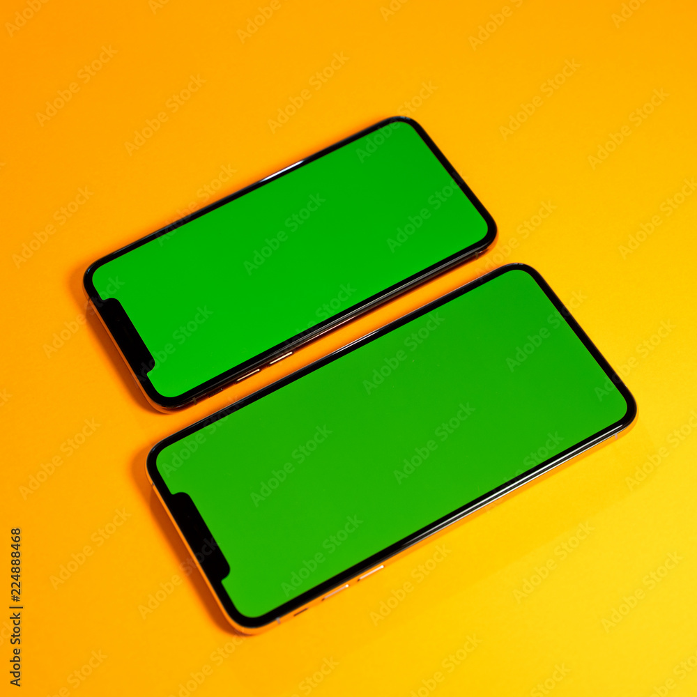 Green chroma key on new mobile smartphne as hero object on bright glamorous modern neon pop orange background - smartphone ready to insert your app Green chroma key on new mobile smartphne as hero object on bright glamorous modern neon pop orange background - smartphone ready to insert your app