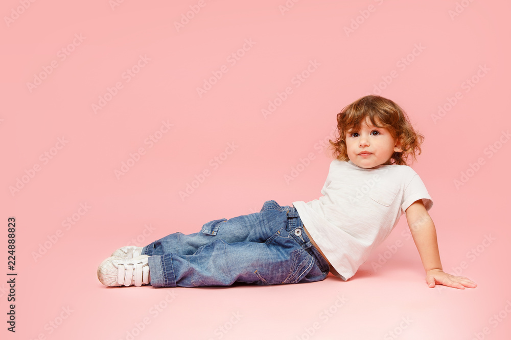 Portrait of happy joyful beautiful little boy, studio shot on pink