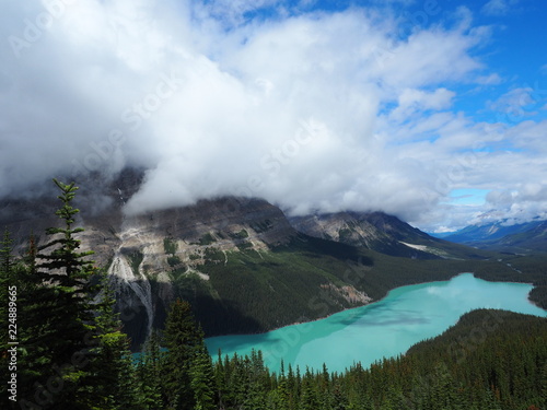 landscape with lake between mountains and clouds