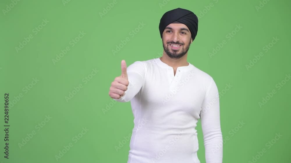 Young happy bearded Indian man giving thumbs up Young happy bearded Indian man giving thumbs up