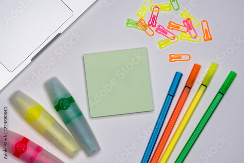 Mix of office supplies around sticky note on a table background. Copy space.