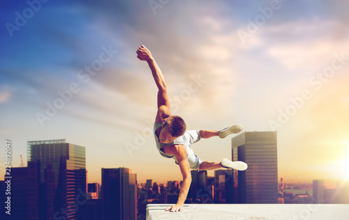 extreme sport, parkour and people concept - young man jumping high over tokyo city background