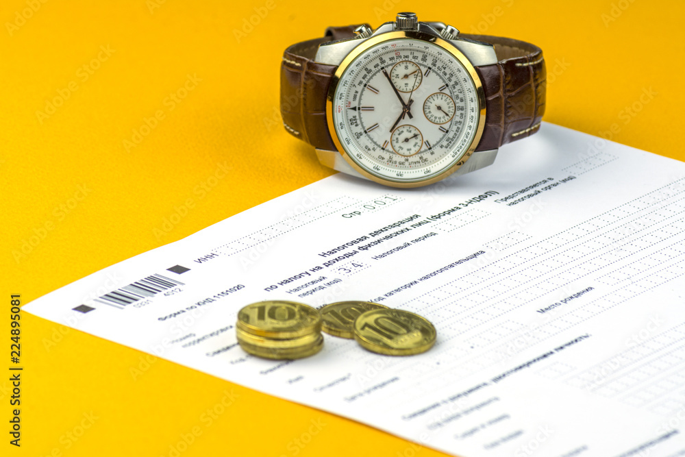 Russian annual tax Declaration of taxes of individuals. The Form 3-NDFL . A few Russian coins and watch are on the sheet of the Declaration.