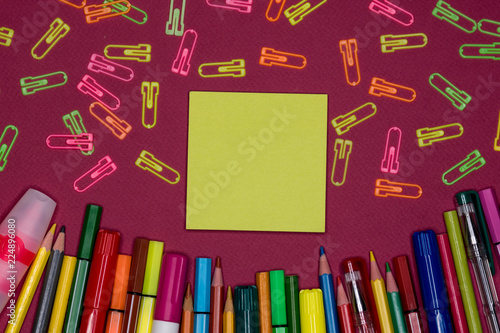 Sticky note, pencils on colorful background, blank copy space