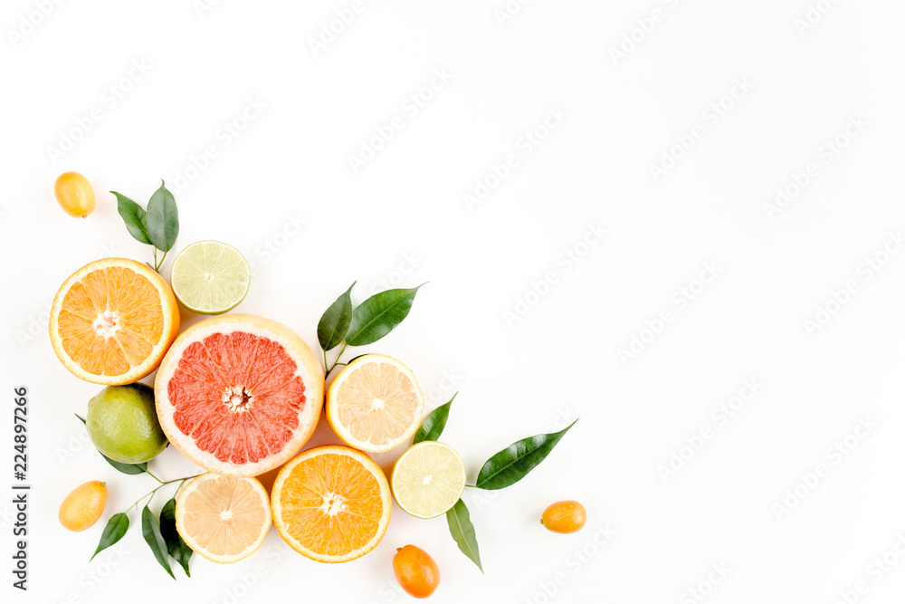 Fototapeta Creative layout made of summer tropical fruits: grapefruit, orange, lemon, lime and leaves ficus. Food concept. flat lay, top view