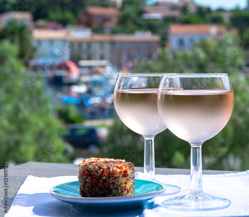 Rose wine of Provence, France, served cold with soft goat cheese on outdoor terrace in two wine glasses