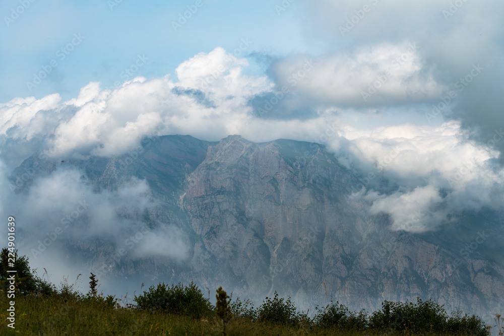 Mountain landscape, green peaks and clouds.