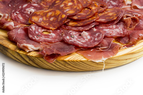 Typical spanish food with ham and sausage on a wooden plate