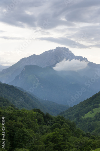 Mountain landscape, green peaks and clouds.