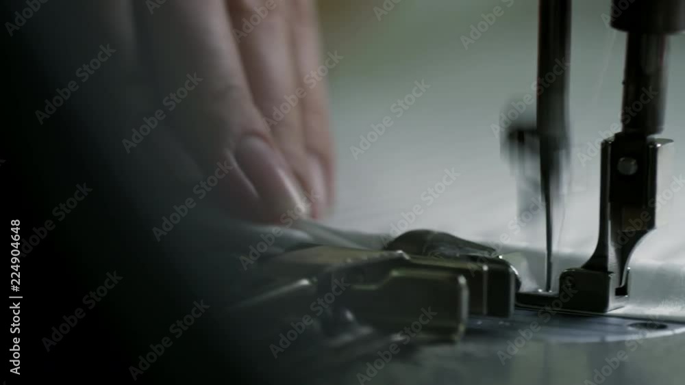 Extreme close up shot of unrecognizable seamstress using sewing machine, tracking right Extreme close up shot of unrecognizable seamstress using sewing machine, tracking right