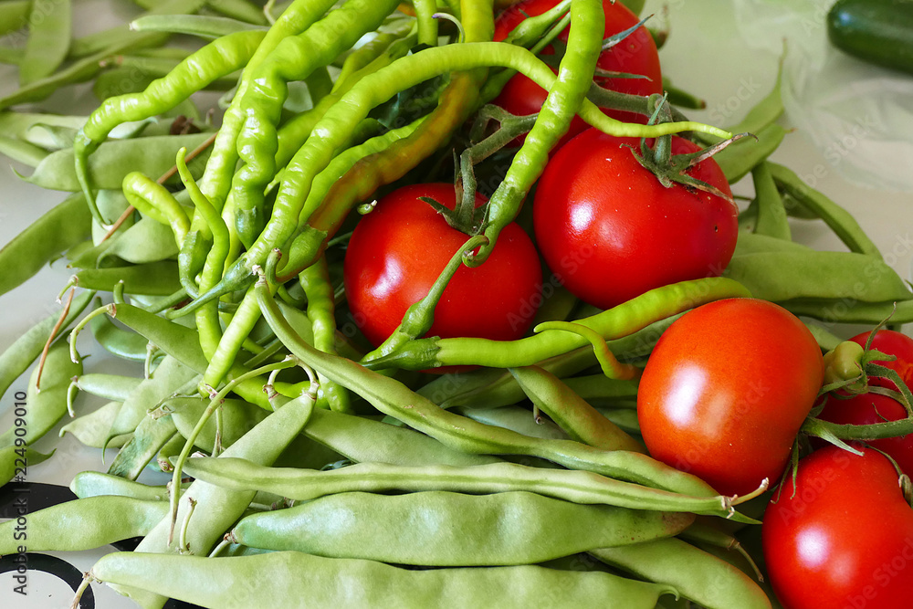 In the kitchen there is green beans, tomatoes and fine pepper,
