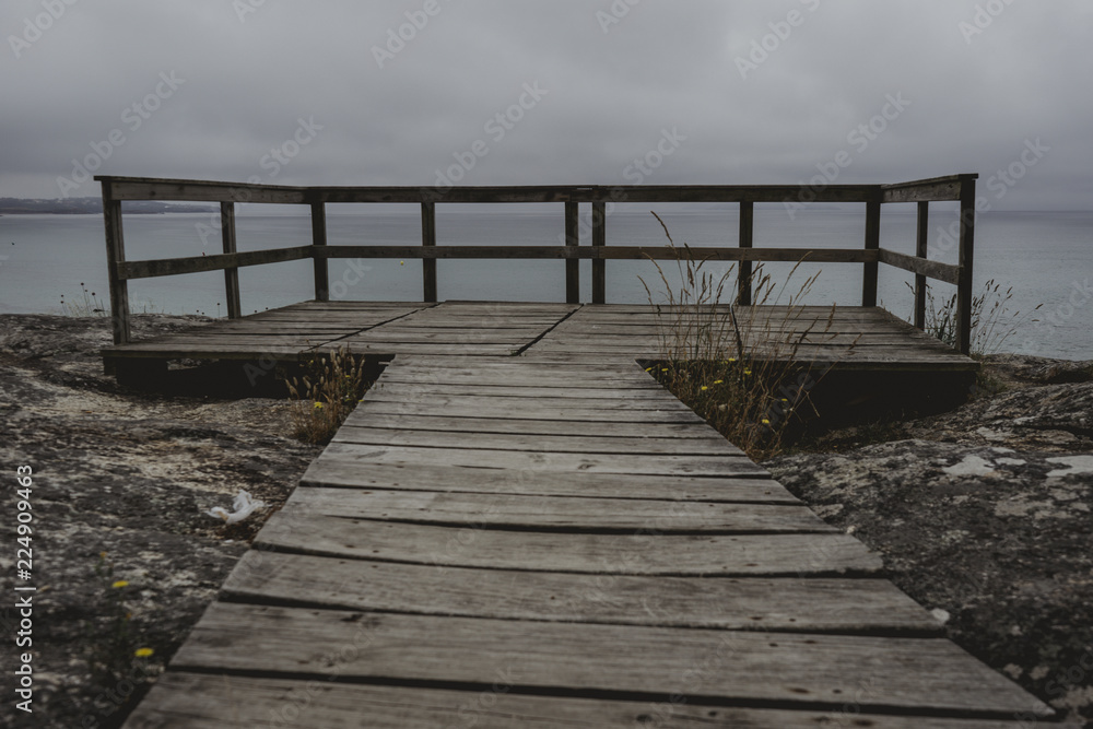 Nice landscape of blue sea with clouds in the sky from a gazebo through a wooden path
