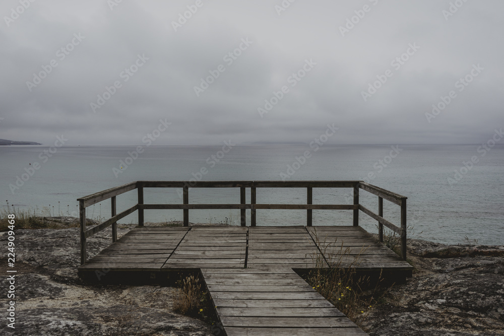 Nice landscape of blue sea with clouds in the sky from a gazebo through a wooden path