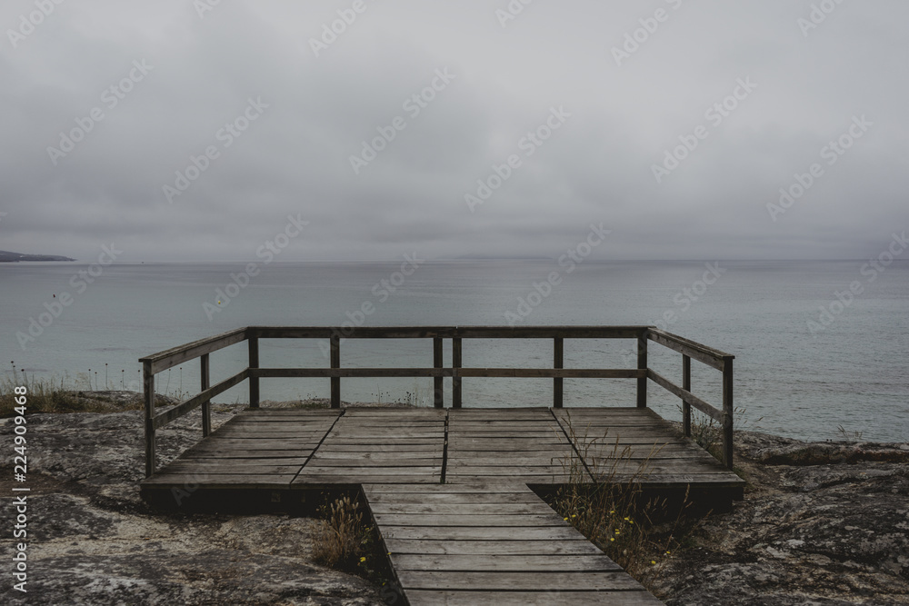 Nice landscape of blue sea with clouds in the sky from a gazebo through a wooden path Nice landscape of blue sea with clouds in the sky from a gazebo through a wooden path
