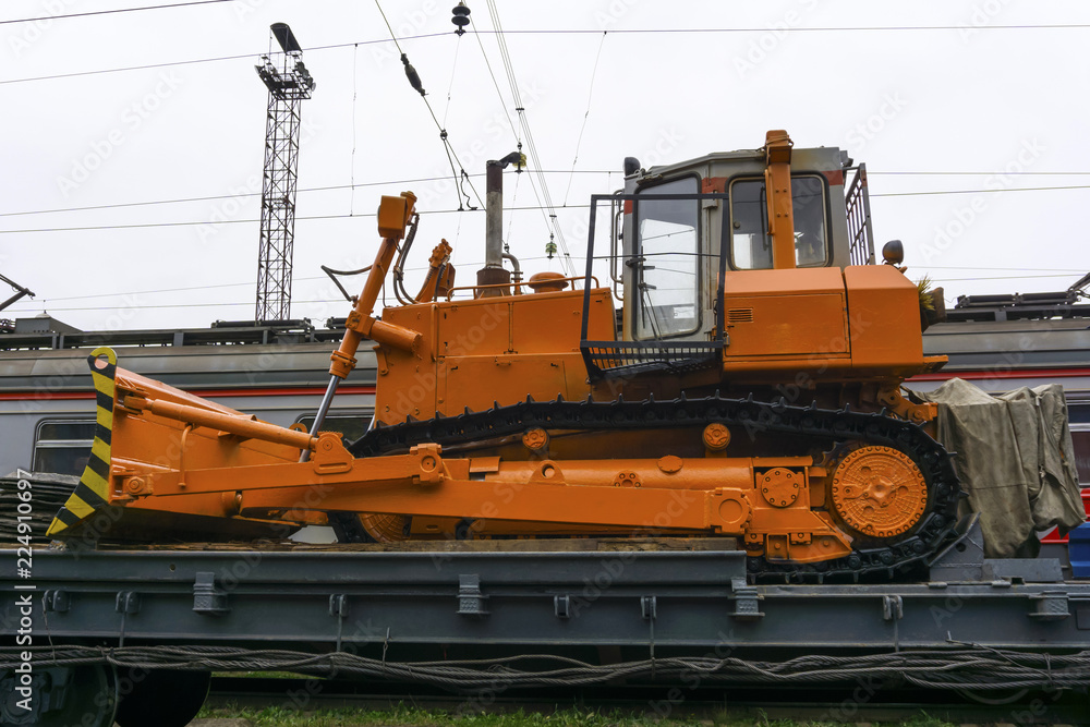 heavy orange bulldozer stands on the flatcar of the train for accident recovery work heavy orange bulldozer stands on the flatcar of the train for accident recovery work