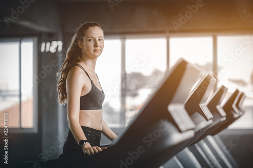 Free Download Fit young woman caucasian running on machine treadmill workout in gym. Glad smiling girl is enjoy with her training process. Concept of fitness, healthy life, Sport, Lifestyle. - GFXLoad
