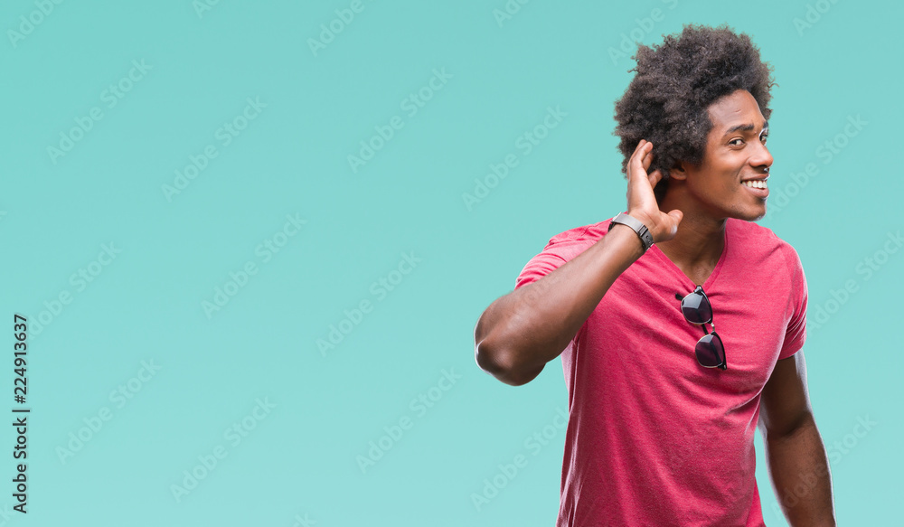 Afro american man over isolated background smiling with hand over ear listening an hearing to rumor or gossip. Deafness concept. Afro american man over isolated background smiling with hand over ear listening an hearing to rumor or gossip. Deafness concept.