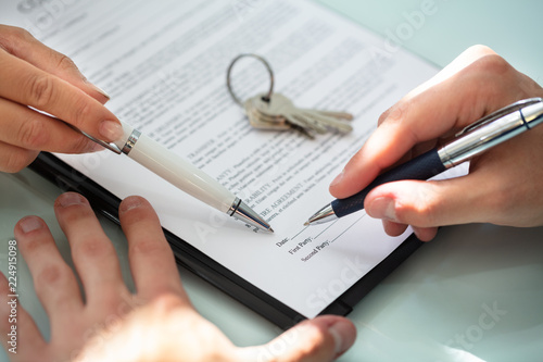 Close-up Of A Person's Hand Filling Contract Form photo