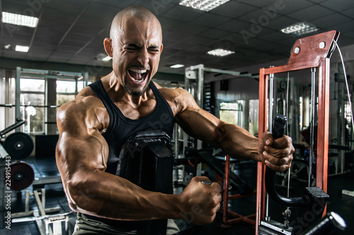 White Muscular man training his back in the gym by training apparatus