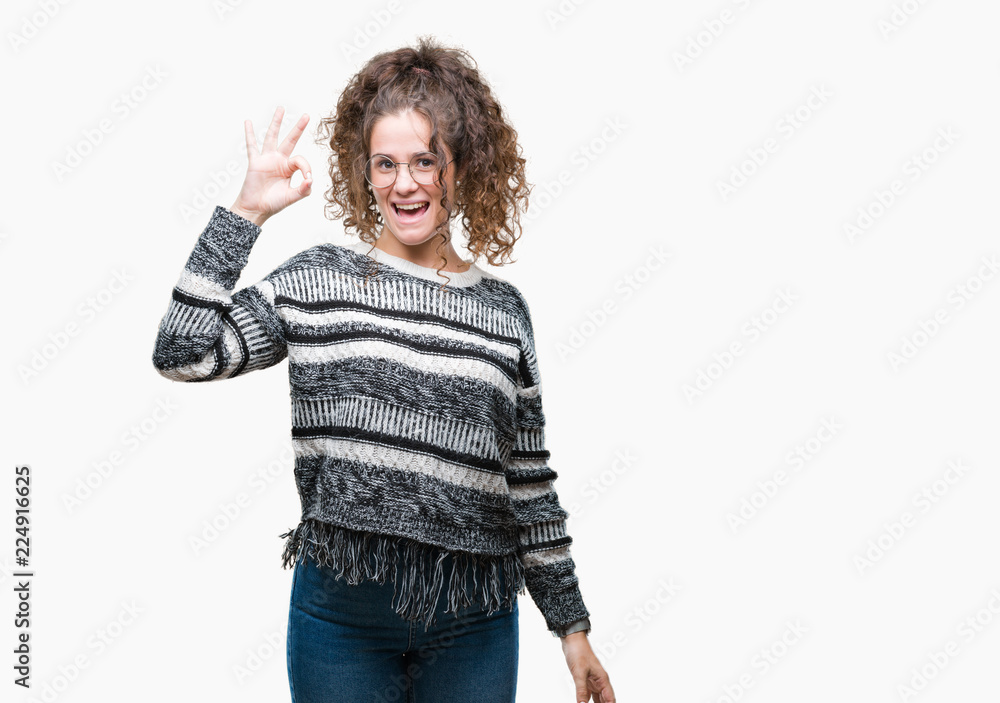 Beautiful brunette curly hair young girl wearing glasses over isolated background smiling positive doing ok sign with hand and fingers. Successful expression. Beautiful brunette curly hair young girl wearing glasses over isolated background smiling positive doing ok sign with hand and fingers. Successful expression.