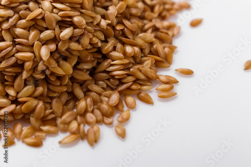 Seeds of golden flax on a white background