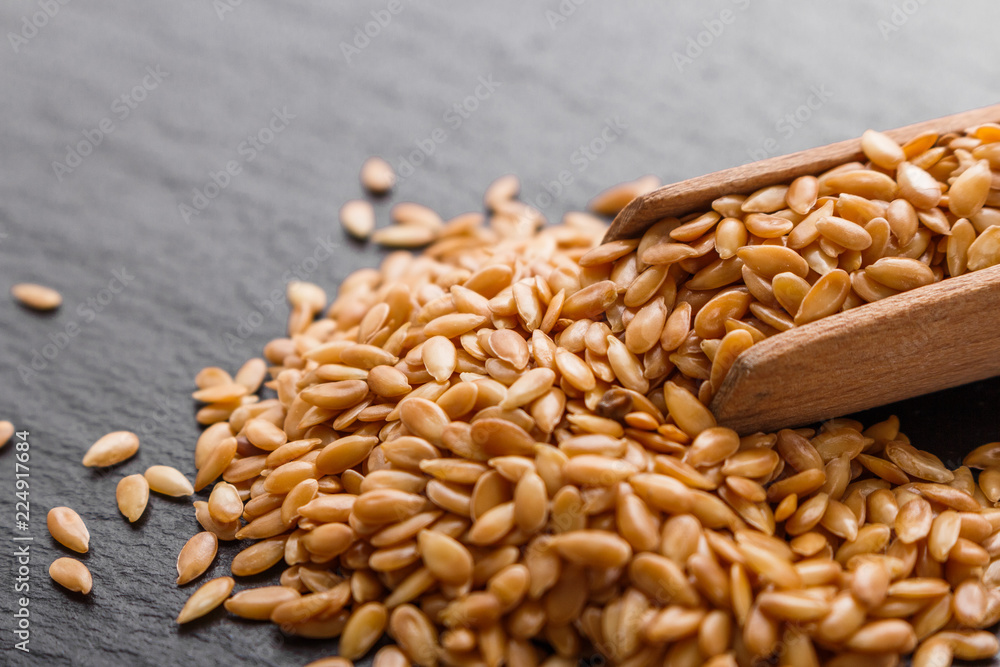 seeds of golden flax on a dark stone background