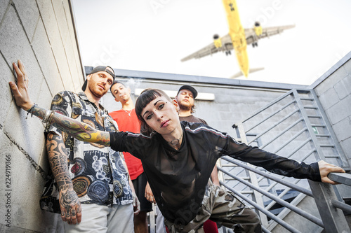 group of rappers posing on the metal stairs