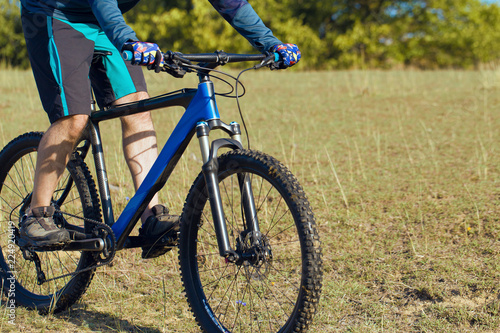 A cyclist rides the hills, Beautiful portrait of a guy on a blue bicycle 