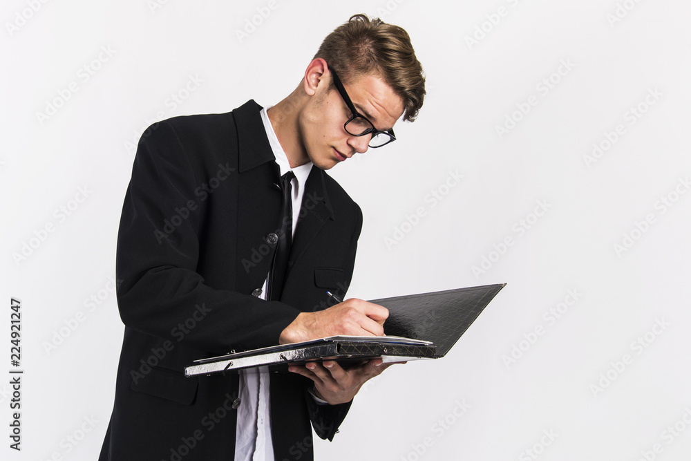 young man in classic black suit with laptop and papers office and  business concept 