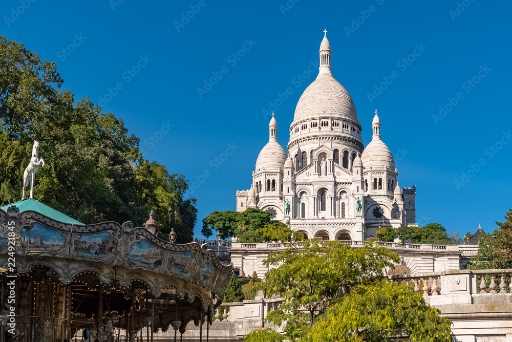 Paris, basilica Sacre-Coeur, famous monument in Montmartre, with a merry-go-round 

