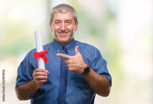 Handsome senior man holding degree over isolated background very happy pointing with hand and finger