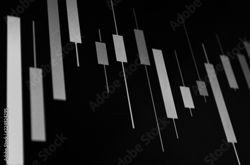 Black and white exchange financial schedule with Japanese candles, out of focus