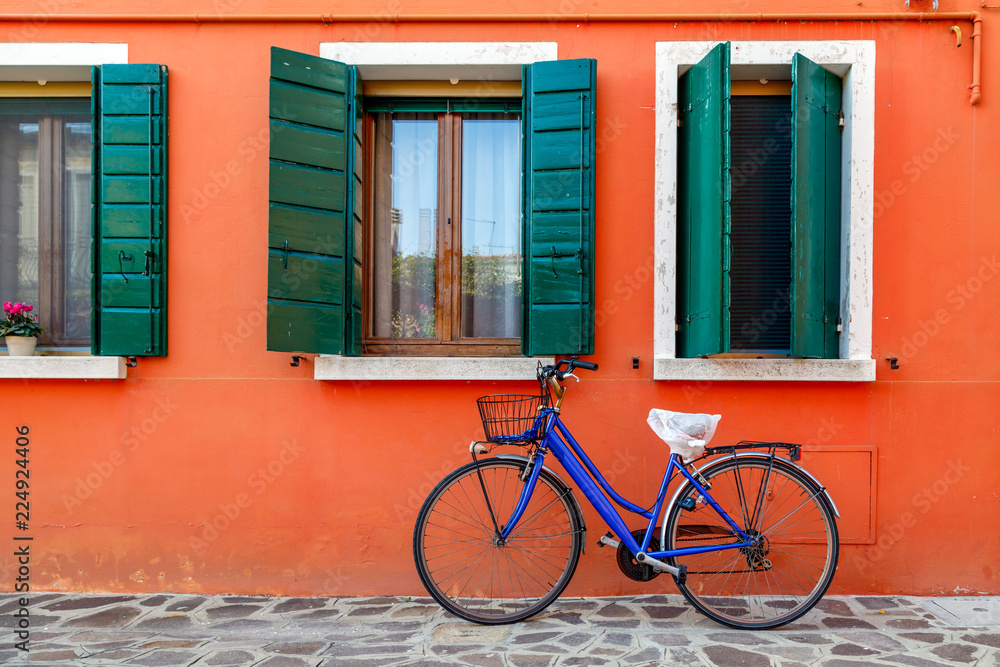Bicycle with a basket by the wall of colorful house in Burano, Venice, Italy. Bicycle with a basket by the wall of colorful house in Burano, Venice, Italy.