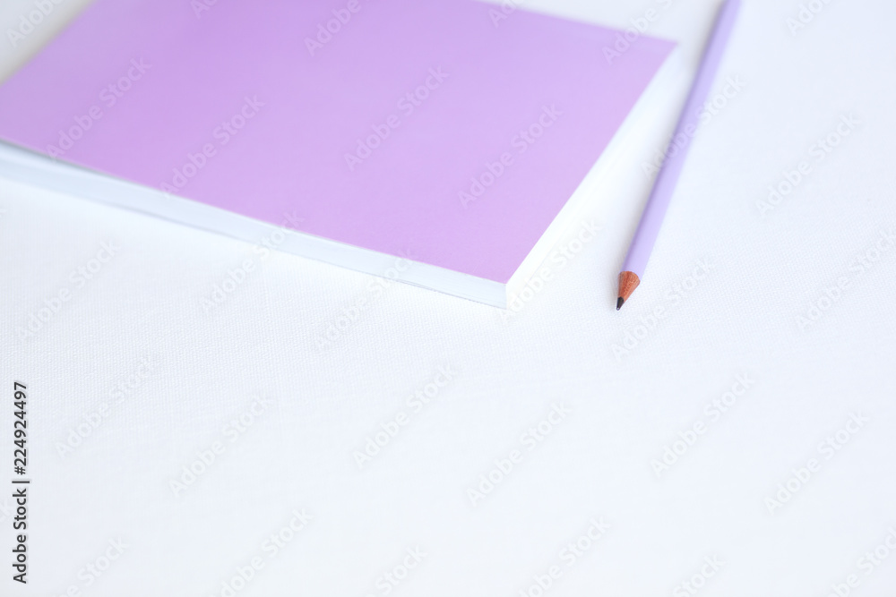 Pink notebook and pencil on white background. Selective focus Pink notebook and pencil on white background. Selective focus